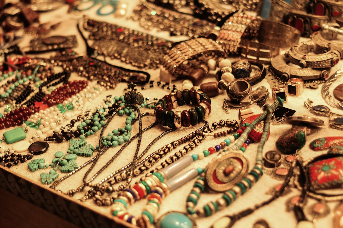 Handcrafted jewelry with colorful beads and stones displayed on a surface.