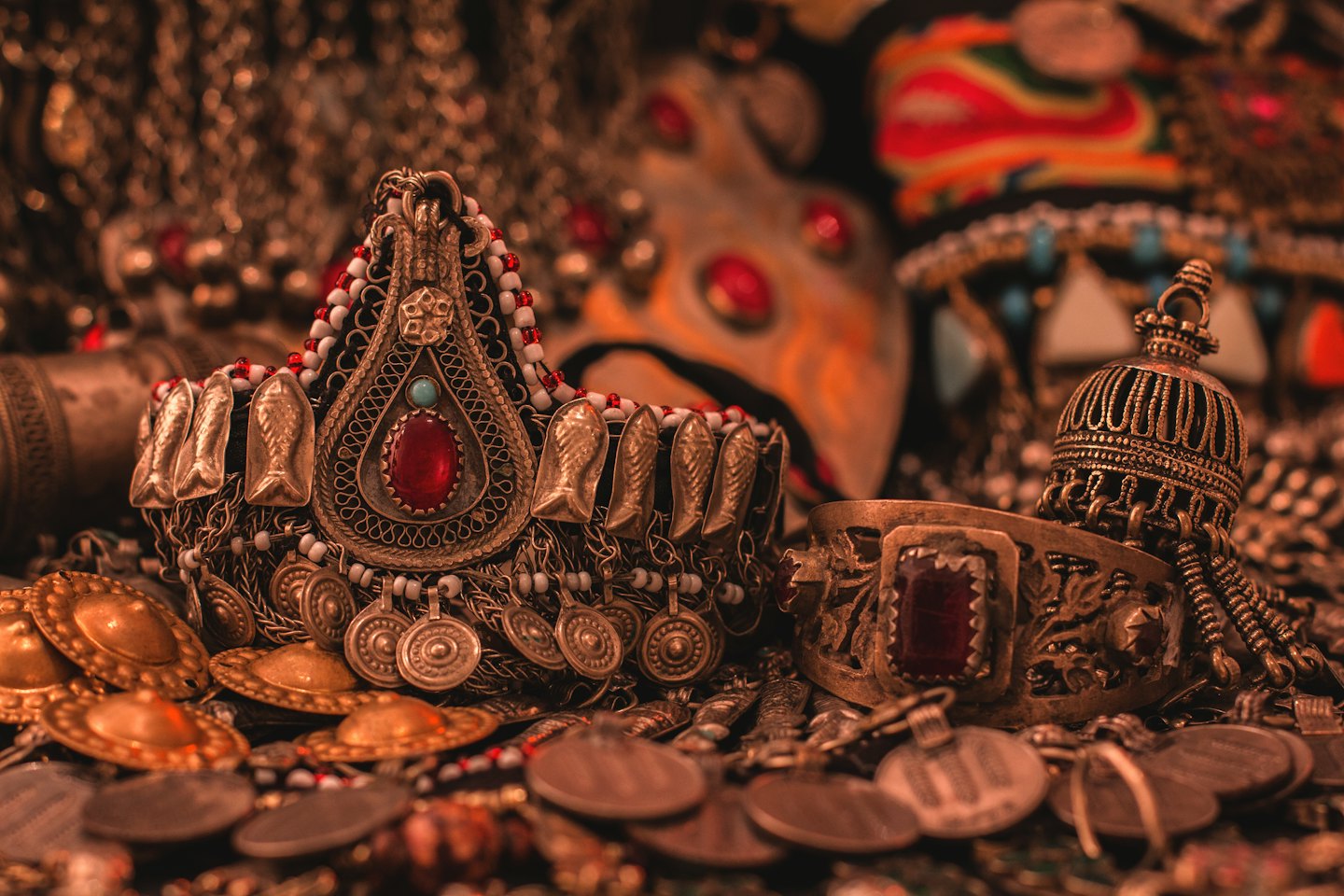 Detailed metal necklace and bracelet with stones and coins.
